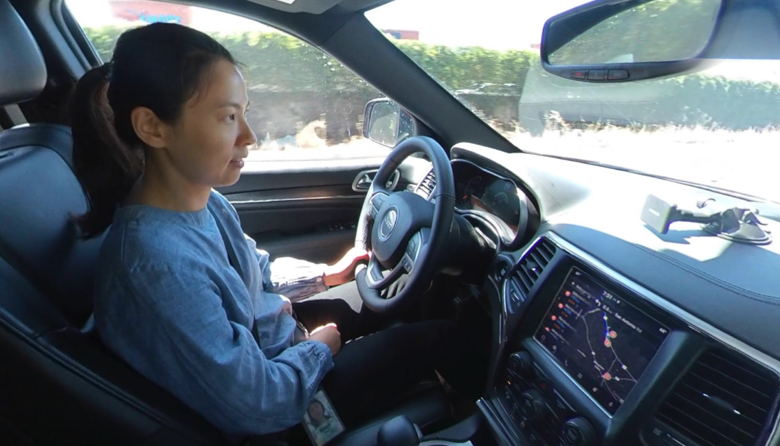 My teammate Diane Wei drives the test vehicle on a sunny road during a pilot session, eyes ahead, with Google Maps navigation on the dashboard display.