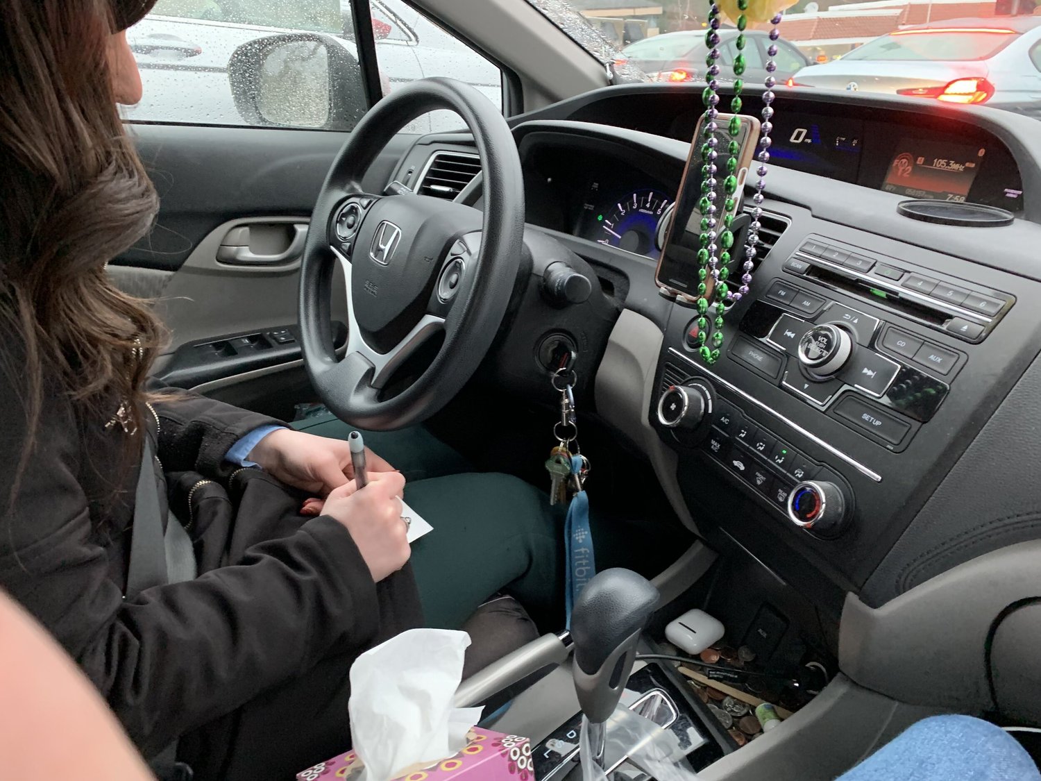 View from the passenger seat during a ride-along study — a driver interacts with a phone mounted in a testing vehicle on public roads.
